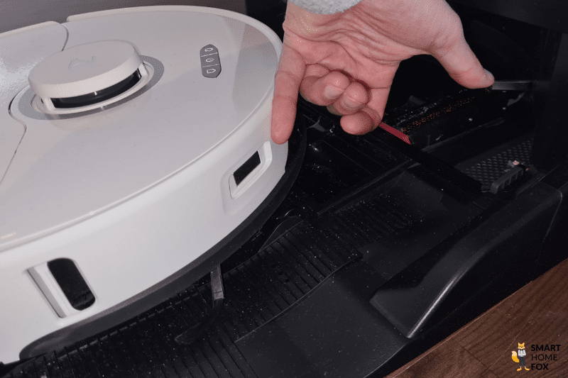 Пальцы указывают на зарядные контакты Roborock S8 Pro Ultra и Ultra Station.